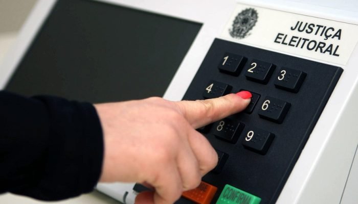 Mulher digita em urna eletrônica: mesmo com cotas, candidatas recebem menos que os homens em ele...