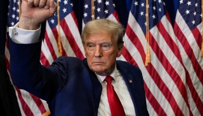 1 de 1 Imagem colorida mostra o ex-presidente dos EUA Donald Trump em frente a bandeiras do país...